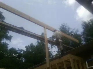 Carpenter setting a ridge beam over a new addition frame — Ice Dam Removal by Roofing Brothers in Nottingham