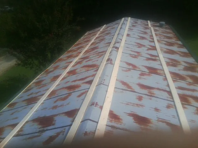 Rusted metal roof panels with new wood purlins before replacement — Storm Damage Roof Repair in Nottingham by Roofing Brothers